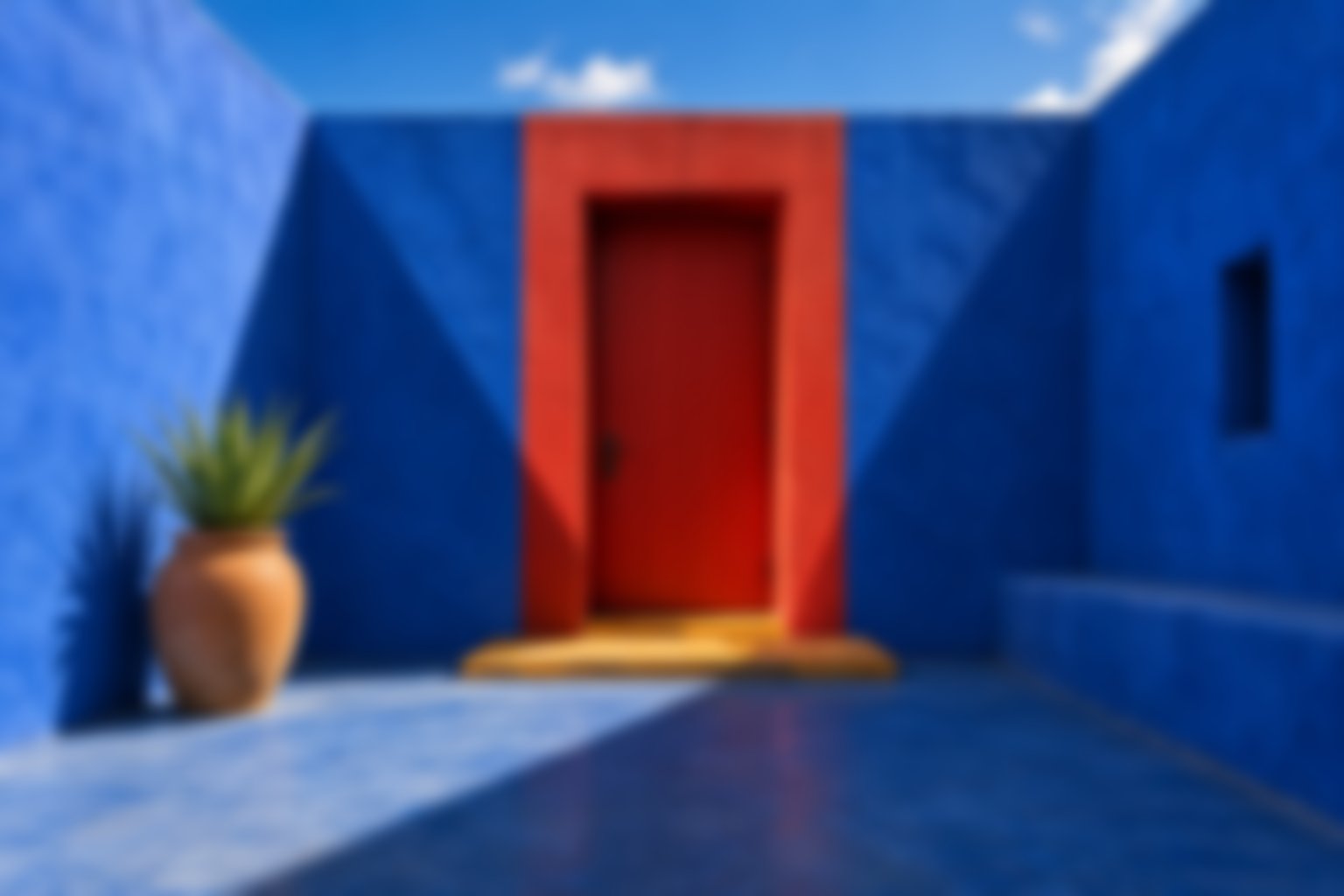 Blurred rendition of a cobalt courtyard with a vermilion doorway in hard sunlight