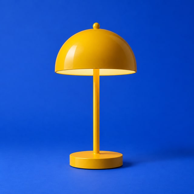 A marigold metal lamp on a cobalt blue background