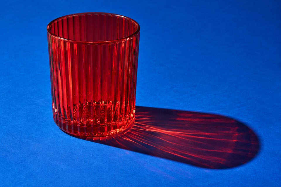 Red ribbed glass casting colored light on cobalt paper