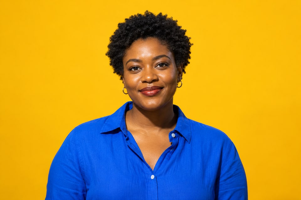 A woman with short natural curls in cobalt against marigold