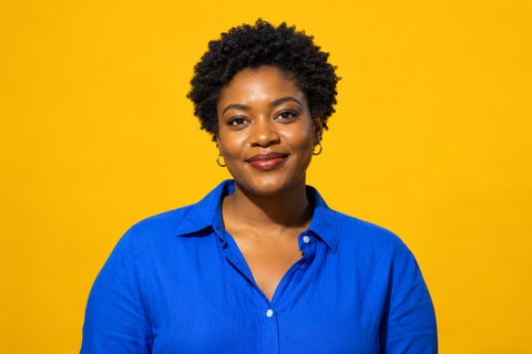 A woman with short natural curls in cobalt against marigold