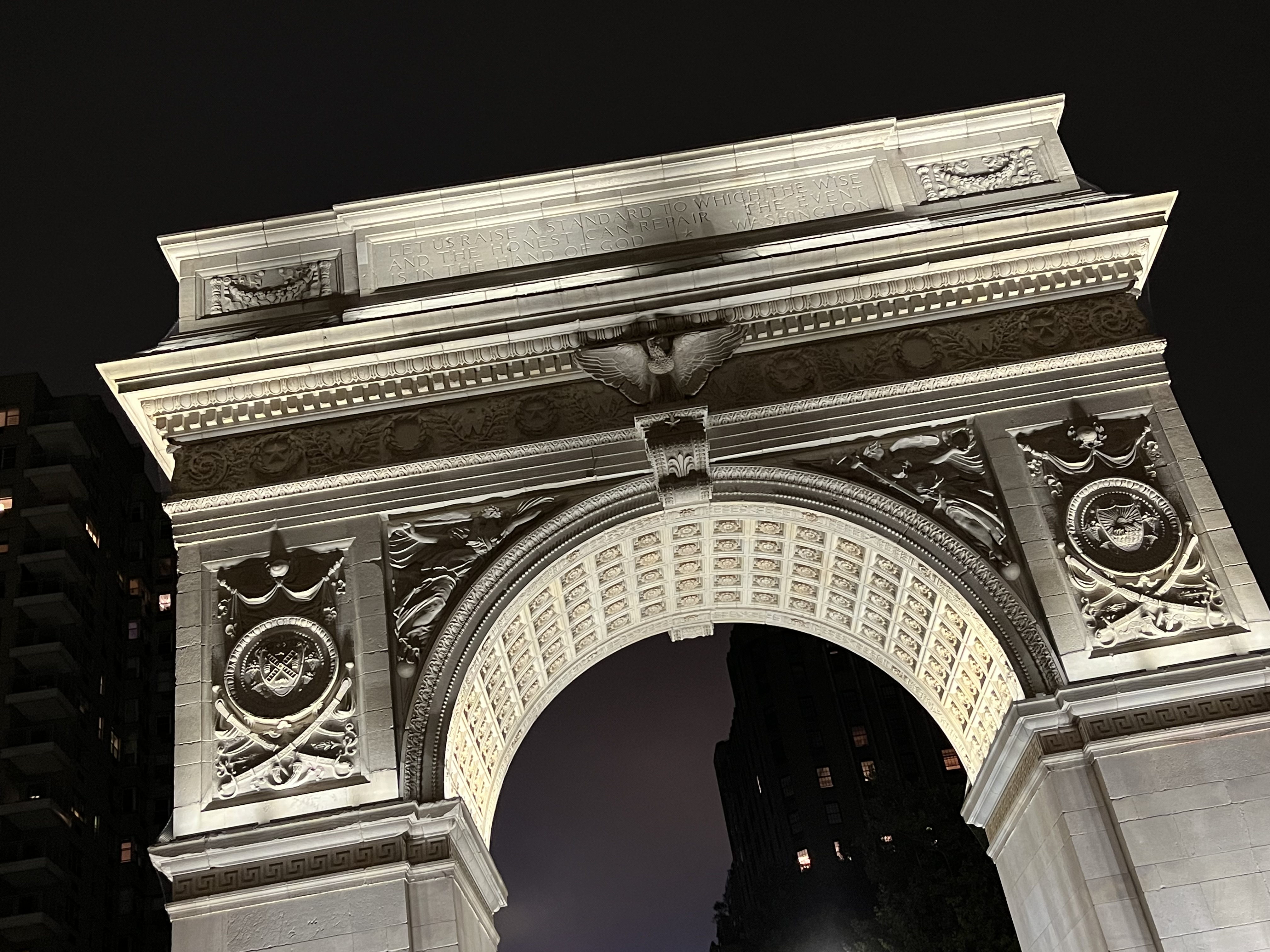 A stone arch lit from below at night.