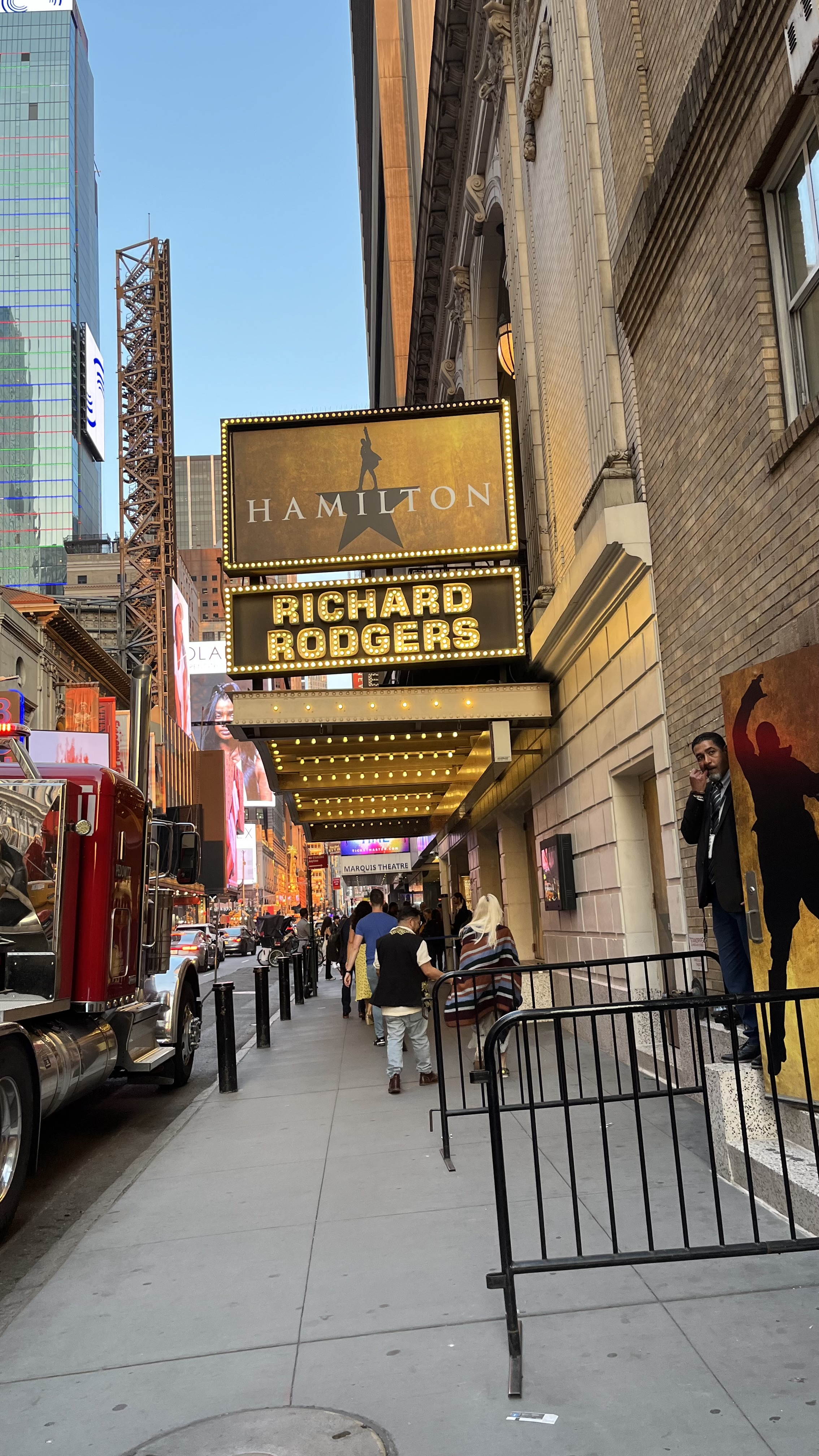 A theater marquee over a busy sidewalk.
