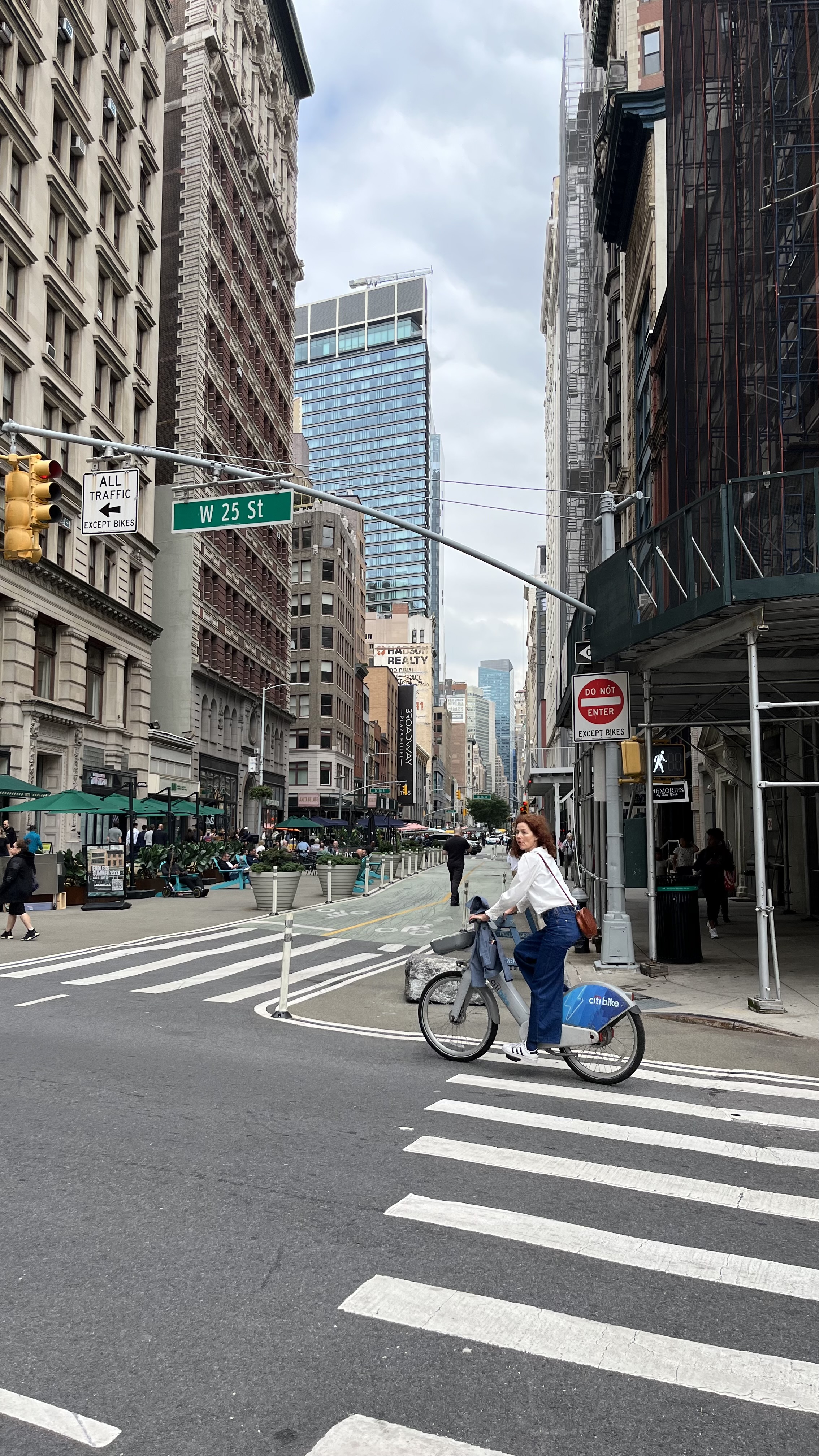 A cyclist crossing a daytime Manhattan street.