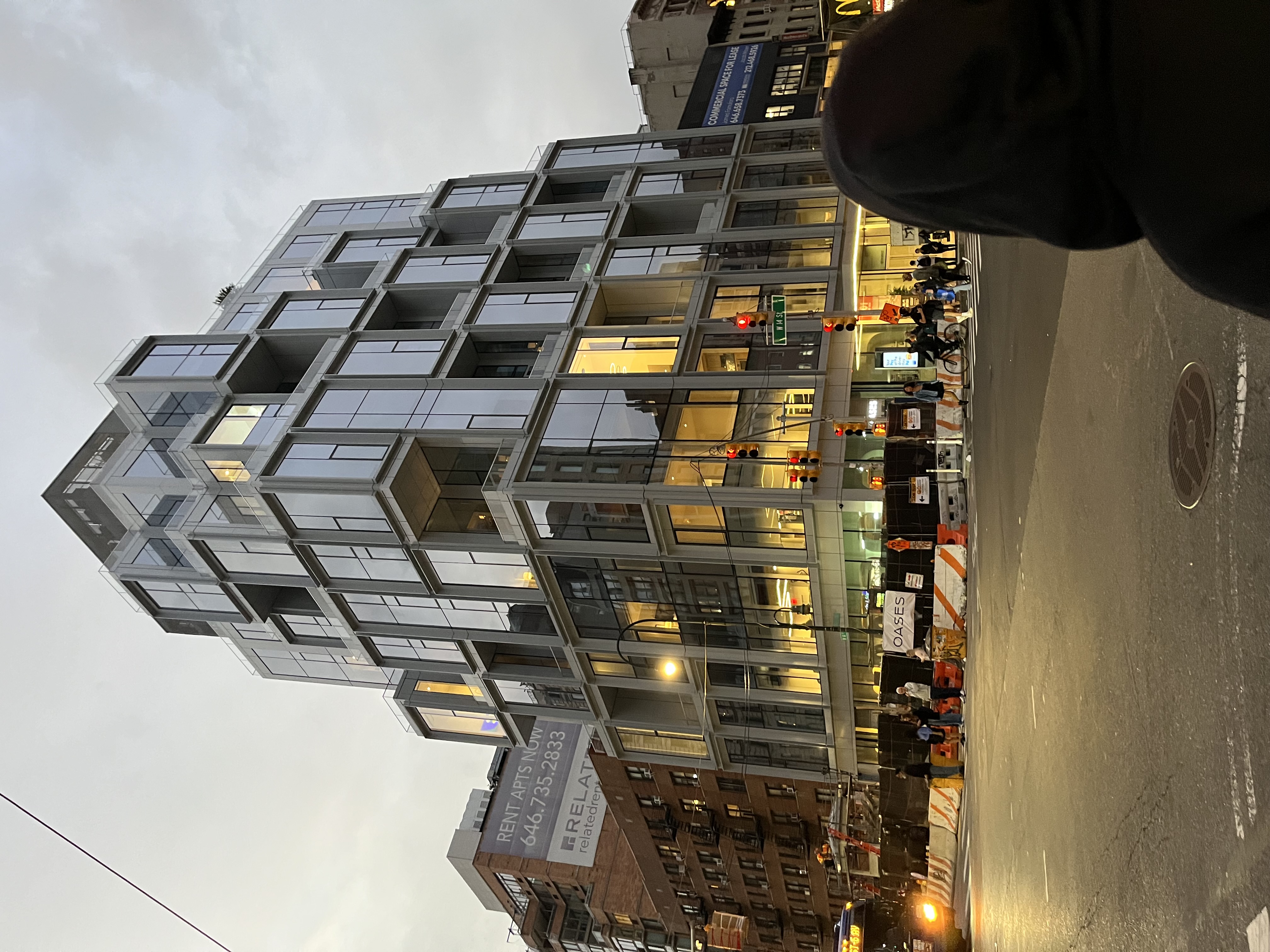 A glass apartment building at dusk.