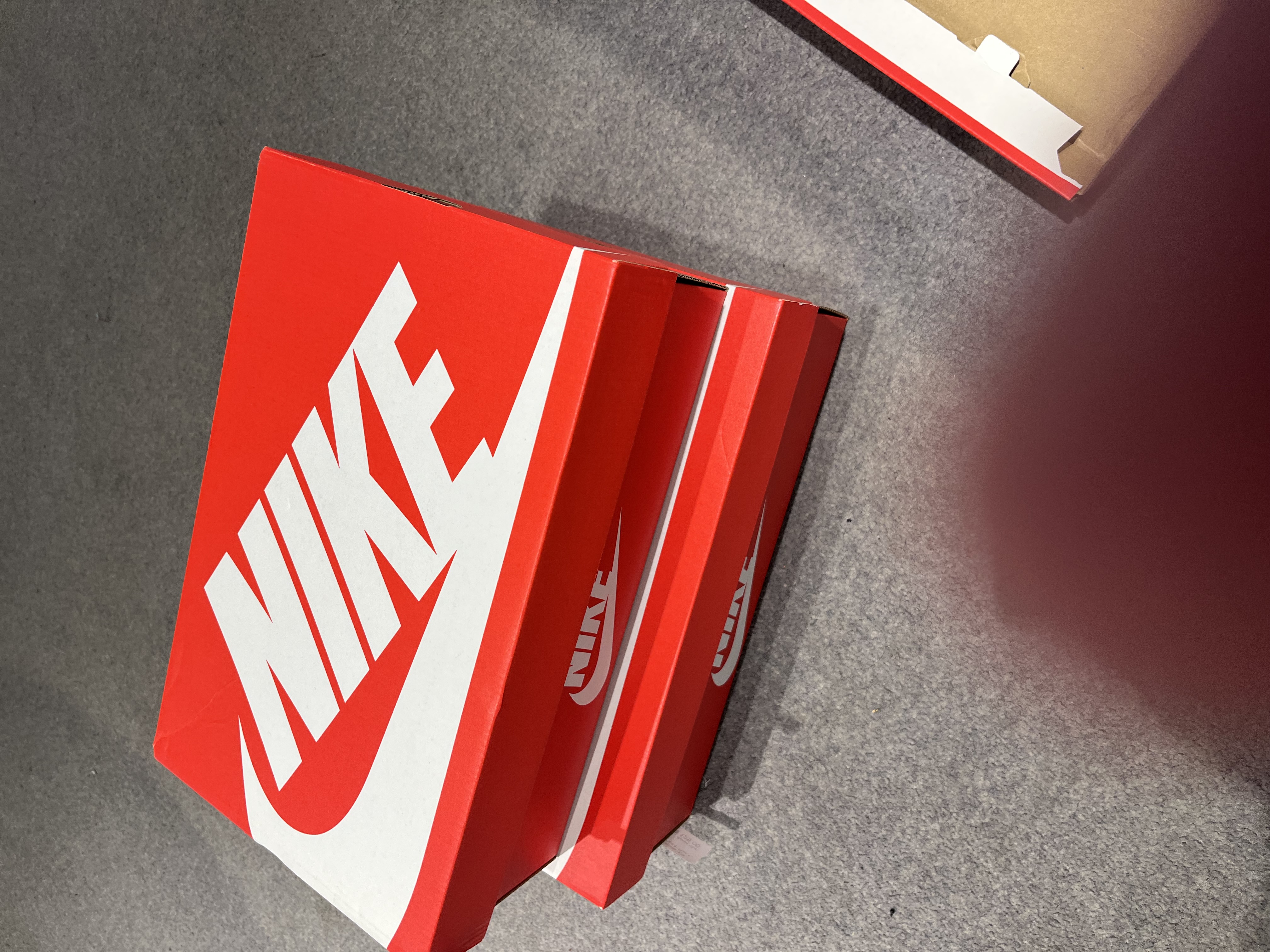 Oversized red shoeboxes stacked in a store.