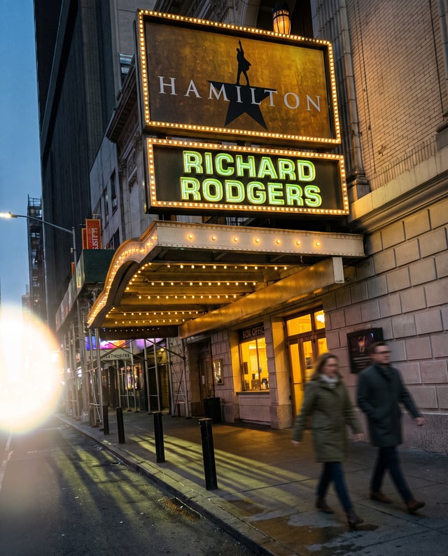 The Hamilton marquee glowing above pedestrians outside the Richard Rodgers Theatre, made by Muse.
